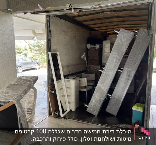 משאית הובלה עם רהיטים וארגזים עטופים בניילון